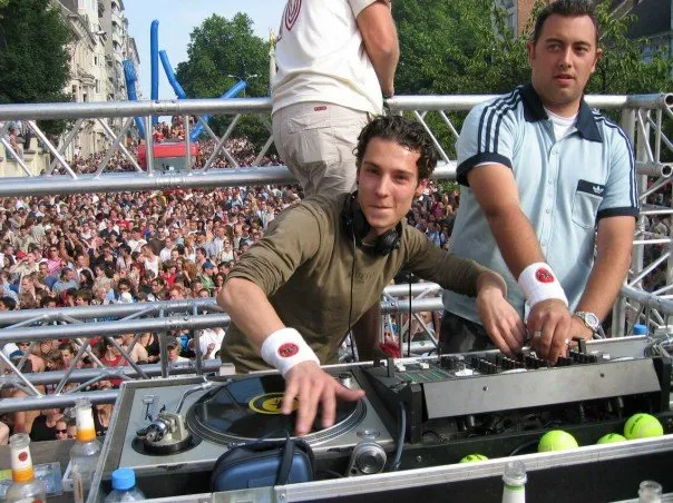 Twee DJ's op een buitenpodium boven een grote menigte